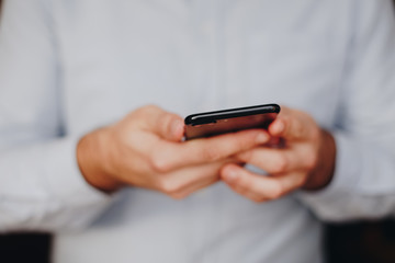 close up of man using smartphone. concept of phone addiction. young business man typing and browsing social media on his phone. 