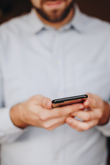 close up of man using smartphone. concept of phone addiction. young business man typing and browsing social media on his phone. 
