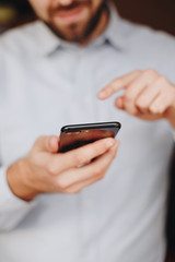 close up of man using smartphone. concept of phone addiction. young business man typing and browsing social media on his phone. 