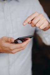 close up of man using smartphone. concept of phone addiction. young business man typing and browsing social media on his phone. 