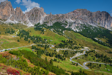 winding road up hills between mountains with lonely houses and hotels