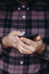 close up of man using smartphone. concept of phone addiction. young business man typing and browsing social media on his phone. 