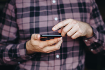 close up of man using smartphone. concept of phone addiction. young business man typing and browsing social media on his phone. 