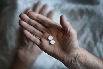 An elderly man drinks a medicine. A pensioner takes a pill medicine.