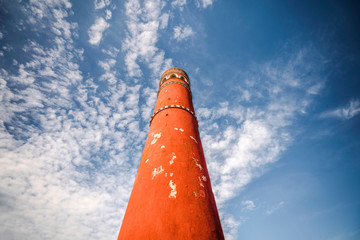 Tall red chimney tower under a blue sky