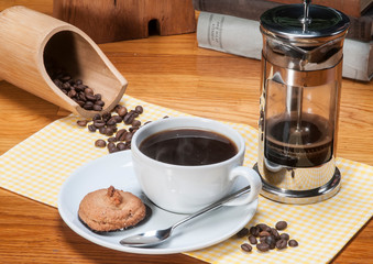 French press coffee maker with cup and coffee beans