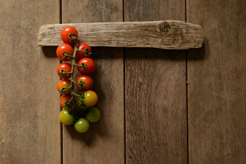 branch of cherry tomatoes on an old wooden table

