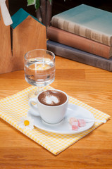 turkish coffe and delights on white plate with books on wooden table