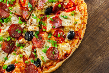 Pizza with Chicken meat, Mozzarella cheese, pepperoni, tomato, olive, salami. Italian pizza on wooden background