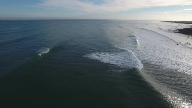 Aerial view of surfing volcanic reef waves in Taranaki, New Zealand
