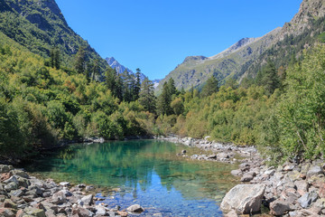 Fototapeta na wymiar Lake scenes in mountains, national park Dombai, Caucasus, Russia, Europe. Sunshine weather, blue color sky, far away green trees. Colorful summer day, time