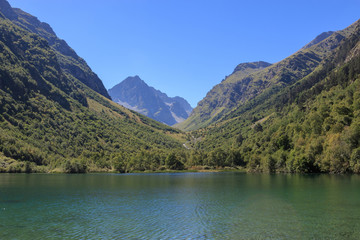 Lake scenes in mountains, national park Dombai, Caucasus, Russia, Europe. Sunshine weather, blue color sky, far away green trees. Colorful summer day, time
