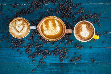 Coffee latte with coffee beans on blue grunge wooden background