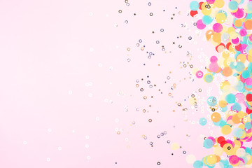 Festive pink background with colorful confetti and sparkles.