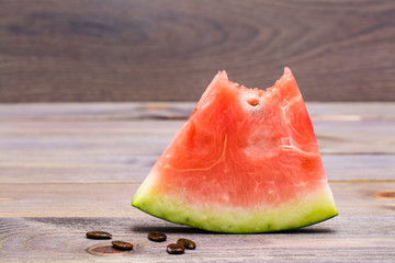 A bit of watermelon and watermelon seeds on a wooden table