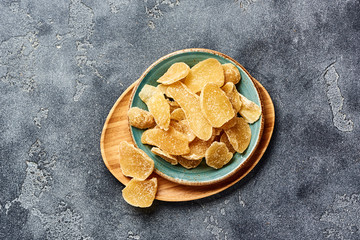 Dried sweet ginger with sugar on a gray table. Top view.