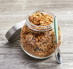 Homemade granola in a glass jar on a wooden table