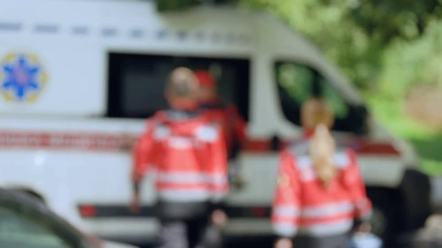 Ambulance crew getting into transport, fast and professional help, background