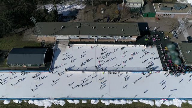 Aerial static footage of ice skating rink frozen body of water where people can skate and play winter sports this oval track is artificial where a coolant produces cold temperatures in surface below