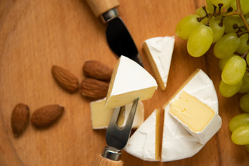 cheese camembert with raspberries and grapes on table