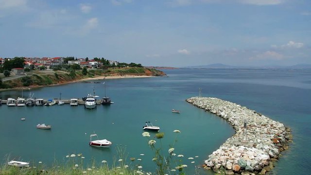 nea Fokea summer resort at Kassandra of Halkidiki peninsula in Greece, Bay with parking for yachts on the background of the old fortress, fortress over bay on aegean sea