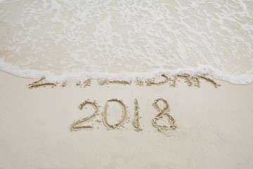 zanzibar script on light sand and ocean wave