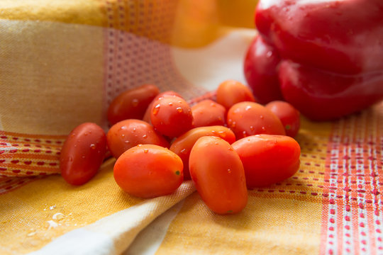 Fresh And Juicy Plum Tomatoes With Fresh Sweet Red Bell Pepper On A Colorful Towel.