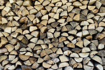 Wood pile wall from triangle cross section trees stumps. Wooden background.