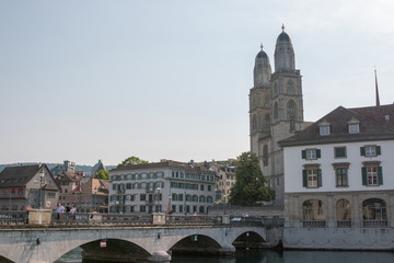 Fototapeta na wymiar Zurich, Switzerland - June 19, 2017: Panoramic view of historic Zurich city center with famous Grossmunster Church and river Limmat. Summer landscape, sunshine weather, blue sky and sunny day