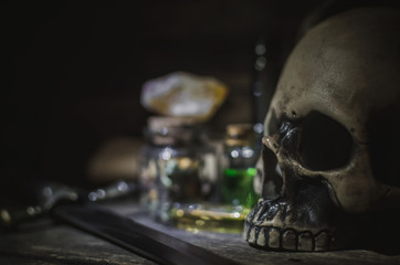 Magic potion and human skull on magic table background. Witchcraft concept.