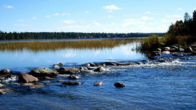 Lake Itasca held behind a man made dam at the headwaters of the Mississippi River at Lake Itasca State Park in Minnesota. Tourists walk on the rocks to say they have walked across the river.