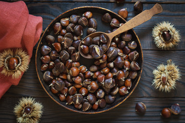 Roasted chestnuts in a pan and whole fruits