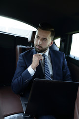 Fototapeta na wymiar businessman with laptop sitting in a comfortable car