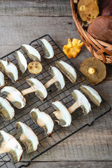 Drying fresh forest mushrooms on wooden table.