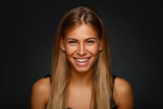 Portrait of young smiling blonde in studio