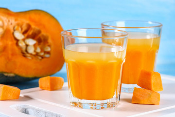 Fototapeta na wymiar Pumpkin smoothie in glasses. Pumpkin juice on a blue table. Autumn drinks.