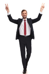 happy businessman walking and celebrating with hands in the air
