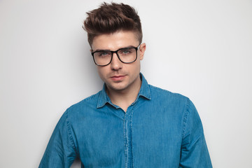 portrait of attractive casual man wearing glasses standing
