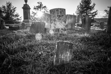 Old cemetery and tombstones in rural town from 1800's, black and white