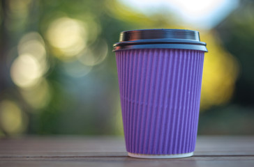 lilac disposable cup for hot drinks on a green background