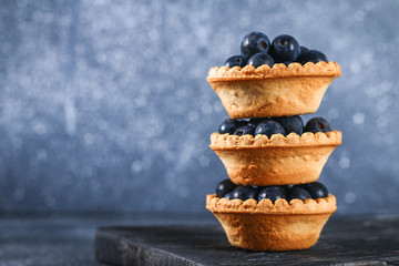 Blue blackthorn berries in sand tartlets on a table.