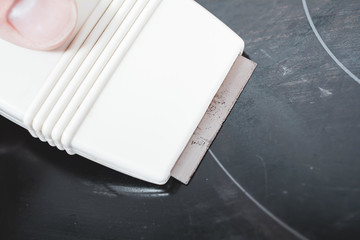 Cleaning A Ceramic Glass Cooktop With A Glass Scraper