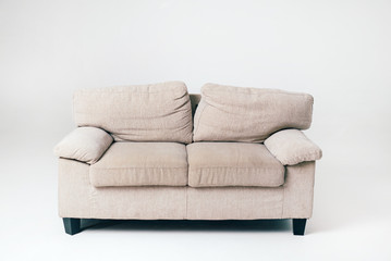 a gray soft sofa with pillows stands in the middle of the room on a white background. Furniture. Interior. Close-up.