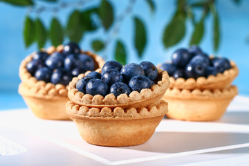 Blue blackthorn berries in sand tartlets on a table.