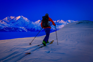 Fototapeta na wymiar Skitouring with amazing view of swiss famous mountains in beautiful winter powder snow of Alps.