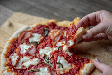 Delicious Italian pizza on a cutting board on dark background