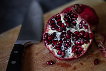 Juicy pomegranate on a cutting board on dark background