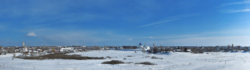 Fototapeta na wymiar Russian towns - Winter panorama of Suzdal under blue sky, Vladimir region, Russia