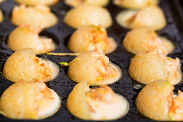 Close up baking prawns in baking pan with holes
