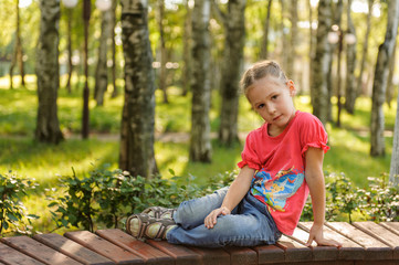 little boy sitting on a bench in autumn park
